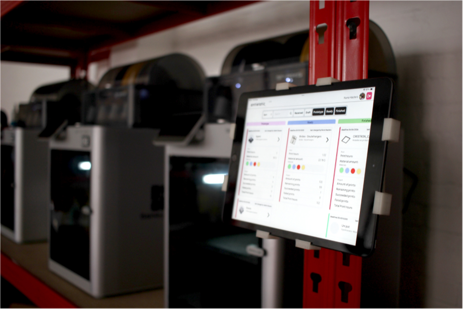 Een tablet met de Antistatic Workflow App in de productieomgeving, met 3D printers op de achtergrond